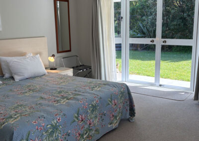 Deluxe King Studio at Ash Grove Motel in Paihia, featuring a spacious king bed and garden access through sliding doors.