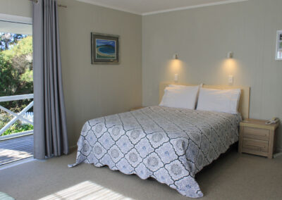 King Studio Cottage bedroom at Ash Grove Motel, featuring a comfortable king bed and private veranda access.