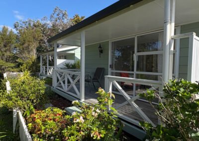 Exterior view of the King Studio Cottage at Ash Grove Motel, featuring a private veranda with garden outlook.