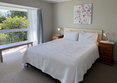 Bright bedroom with king bed in the One Bedroom Unit at Ash Grove Motel.