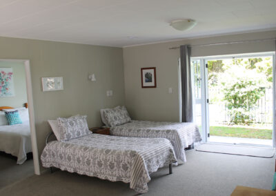 One Bedroom Unit at Ash Grove Motel featuring two single beds and garden access.