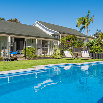 One-bedroom units at Ash Grove Motel in Paihia overlooking the outdoor pool, with garden views and sun loungers.
