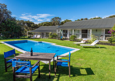 Poolside seating and sun loungers at Ash Grove Motel in Paihia, with studio units overlooking the outdoor swimming pool and gardens.