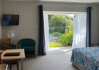 Bright Queen Studio Unit at Ash Grove Motel with outdoor access to the garden and pool area.