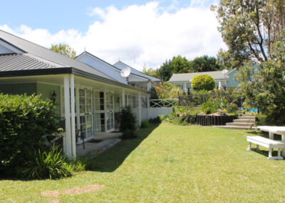 Exterior view of the studio units at Ash Grove Motel in Paihia, with garden seating, landscaped grounds, and sunny outdoor areas.